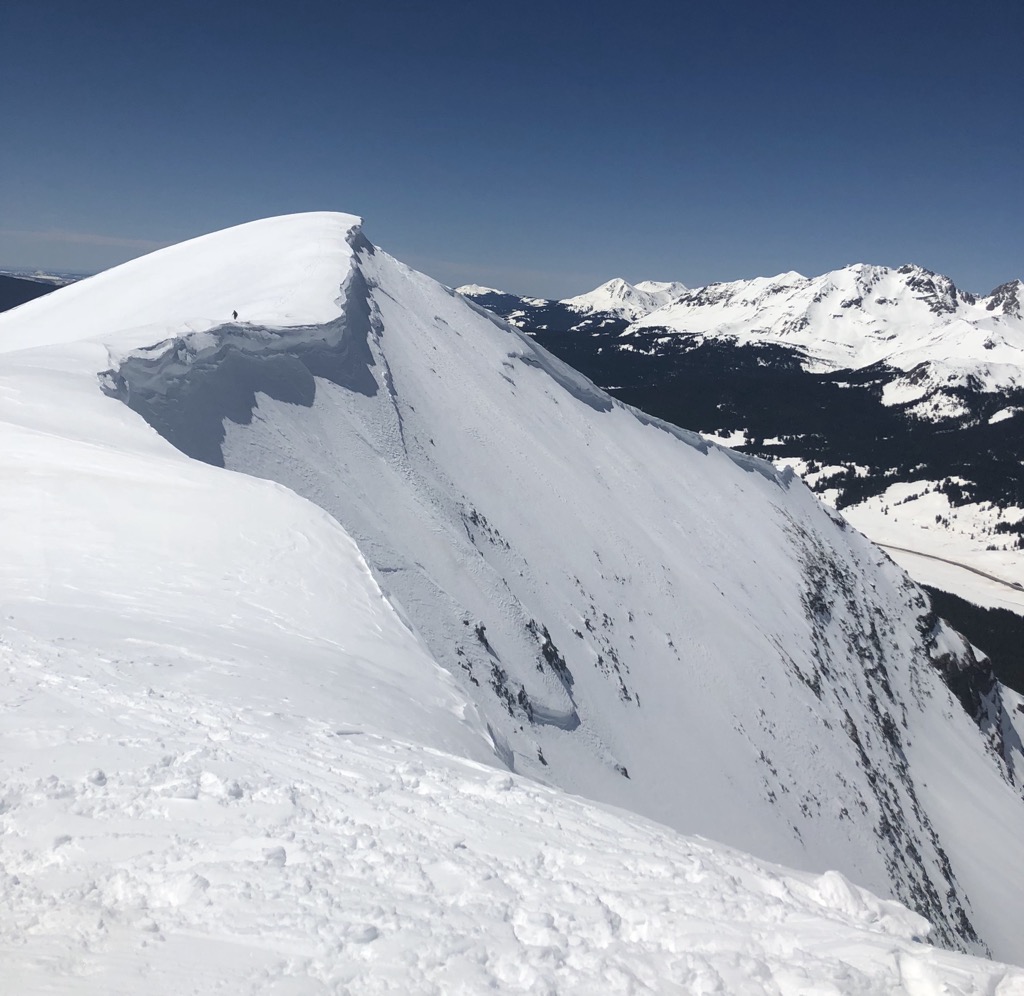 The distant skier is me, giving a few meters of berth from the edge of the cornice. Photo: Sergei Poljak. Avalanche Safety