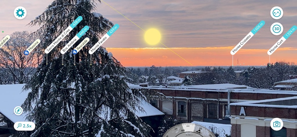 PeakVisor augmented reality view at sunset, with the Sun above snowy trees and peak labels on the horizon