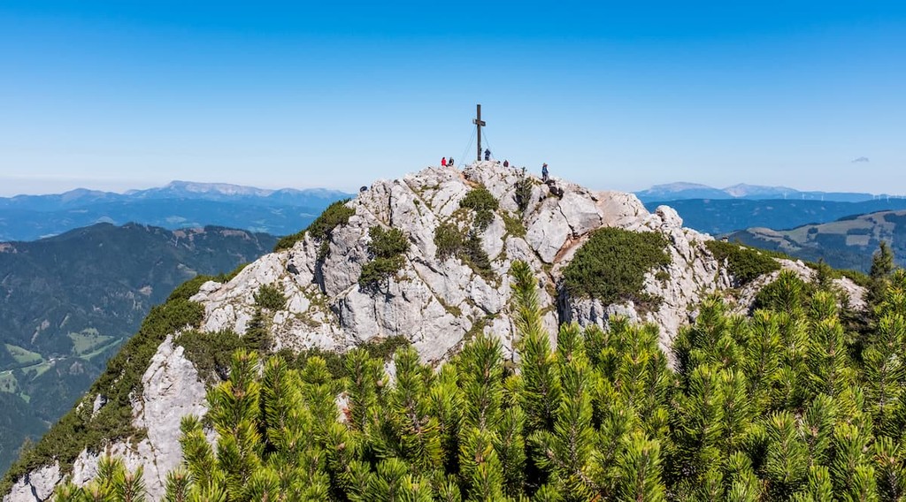 View to summit of mountain Hochlantsch with the cross and some hikers in Styria, Austria